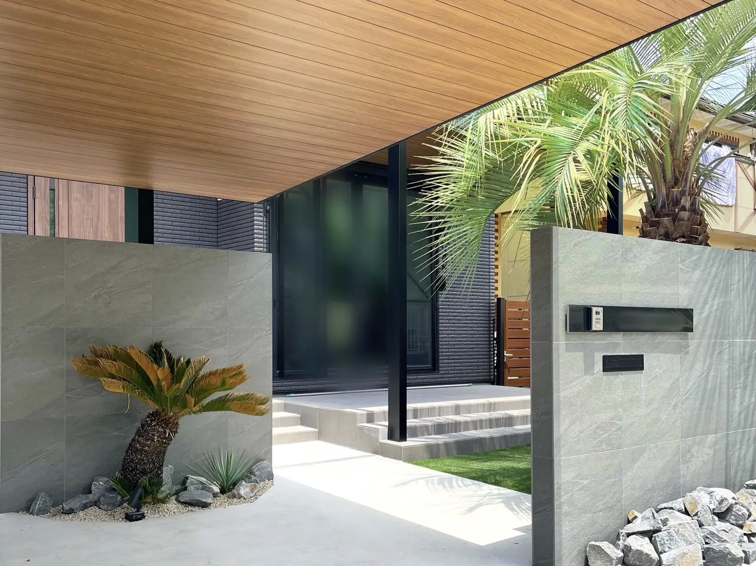 門塀まわりに配置された自然石の花壇と植栽のディテール