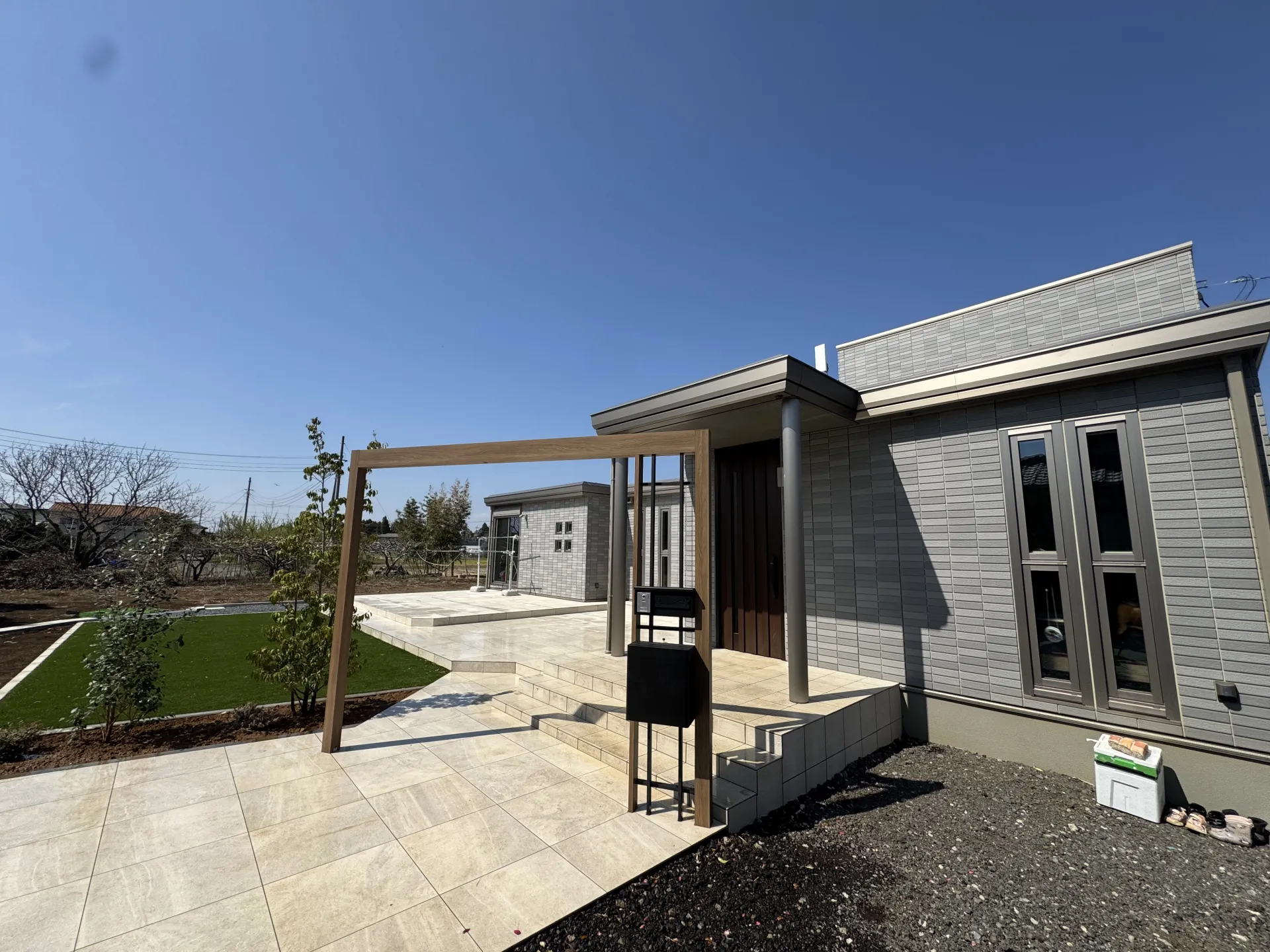 阿見町のセキスイハイムの平屋に施工された、LIXILプラスGの斜めアーチと名古屋モザイク600角大判タイルアプローチの全景